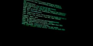 Computer screen with cybersecurity codes in a dark setting.